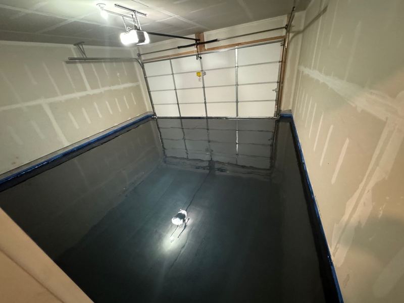 Fresh black epoxy base coat on a garage floor before the metallic color coat, Joliet, IL